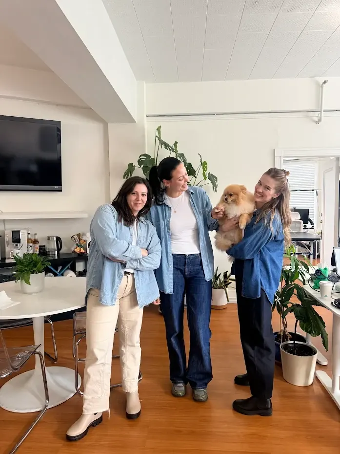 Three teammates with the office Pomeranian